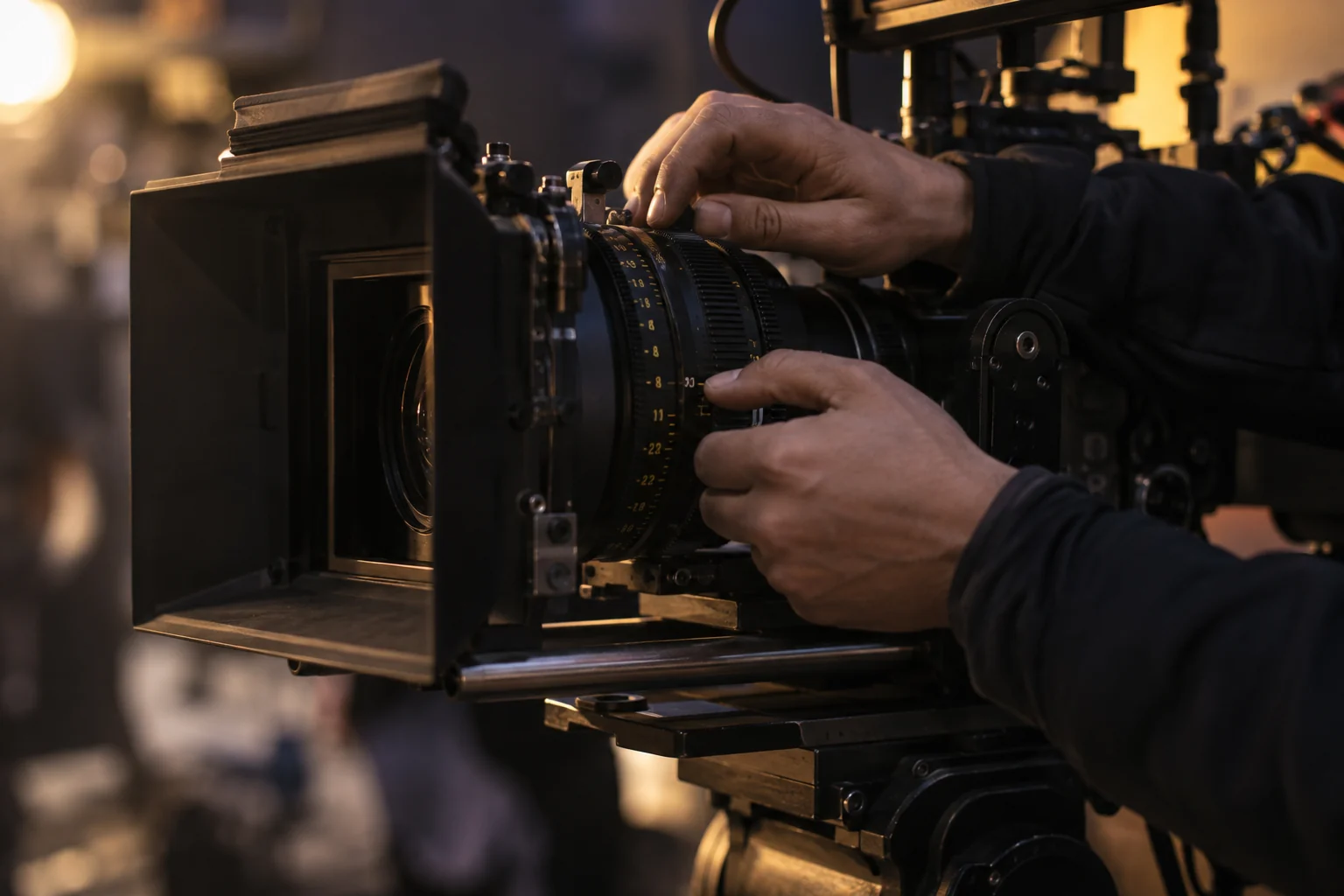 Hands adjusting the focus of a professional cinema camera